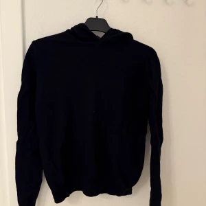 Oscar Jacobson hoodie, svart/marinblå - Mörkblå, stilren hoodie från Oscar Jacobson. Klassisk passform med huva och långa ärmar, perfekt för dig som gillar en enkel och clean look. Passar dig som vill ha något bekvämt men ändå snyggt till vardags.