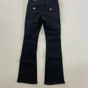 Svarta bootcut jeans med fickdetaljer - Ett par snygga svarta jeans med bootcut passform från Gina tricot. Jeansen är helt nya och inte använda, priset går att diskuteras! 