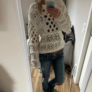 Vit stickad tröja från Lindex - Säljer en vit stickad tröja från Lindex med snyggt hålmönster och unika detaljer. Tröjan har långärmade ärmar och är gjord i grovstickad bomull. Aldrig använd!! Dock inte prislappen kvar💓