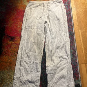 Vita linnebyxor från Gina Tricot - Säljer ett par chill vita linnebyxor från Gina Tricot i storlek 146/152. De har elastisk midja med snörning och är gjorda i mjukt linnematerial. Perfekta för varma dagar när du vill ha en luftig och relaxed vibe.