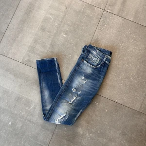 Replay Anbass - Säljer ett par blå jeans från Replay med snygga slitningar och trasiga detaljer framtill. Jeansen har klassisk femficksdesign, normal passform och är tillverkade i jeansmaterial. Stolek: W30/L32