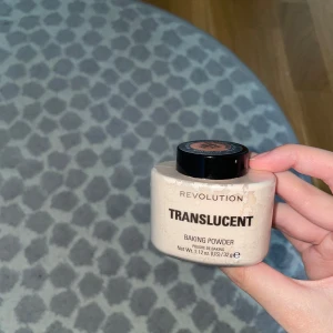 Revolution Translucent Baking Powder - Translucent baking powder från Revolution i en smidig plastburk med svart lock. Perfekt för att sätta din makeup och ge en matt finish utan att påverka hudtonen. Innehåller 32g och är lätt att applicera med borste eller svamp.