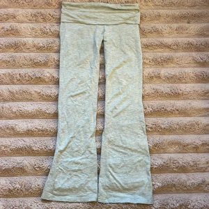 Ljusgrå bootcut byxor Gina Tricot - Supersköna ljusgrå bootcut byxor från Gina Tricot i mjukt bomullsmaterial. De har hög midja som man sedan kan vika ned med bred linning och utsvängda ben för en chill och trendig look. Perfekta att styla med en crop top eller hoodie.