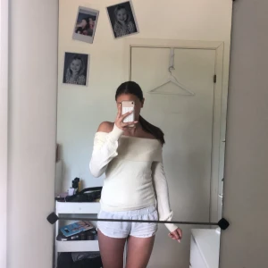 Offshoulder beige stickad tröja - Superfin offshoulder stickad tröja från STOCKH LM i en ljus beige färg. Tröjan har bred ribbad kant upptill, långa ärmar med ribbade muddar och en slim passform. Perfekt för dig som gillar en stilren och trendig look.💓