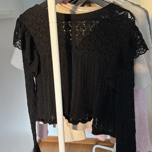 Svart spetsblus från Zara - Supersnygg svart blus från Zara i spets med långärmad design och fina virkade detaljer. Perfekt för dig som gillar en feminin och trendig look. Blusen har rund halsringning och är lätt transparent med vackert mönster. Skriv för bilder på! Inga tecken på användning 