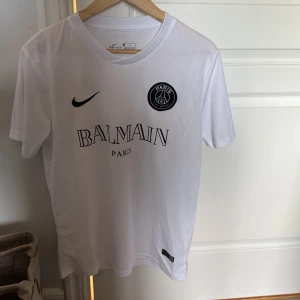 PSG Balmain t shirt - Säljer en helt oanvänd och eftertraktad psg balmain fotbollströja. I storlek S aldrig använt, som helt ny. Drar utomlands snart så hör av er ifall ni vill köpa så att jag hinenr frakta innan! Säljer också en i svart (kolla min profil). En för 600, båda för 1000. 