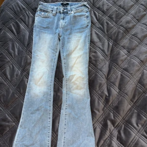 True Religion Bootcut Jeans - Snygga ljusblå jeans från True Religion, modell Becca MidRise Bootcut. Storlek 24 men förkortad några centimer och passar en 164 cm lång person. Säljer pågrund av fel storlek. 