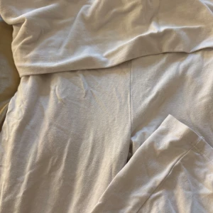 Beiga mjukisbyxor i bomull - Säljer ett par beiga mjukisbyxor i mjukt bomullstyg. De har en enkel och clean design utan synliga detaljer, perfekta för chill dagar hemma eller när du vill vara bekväm. Byxorna har resår i midjan och raka ben.