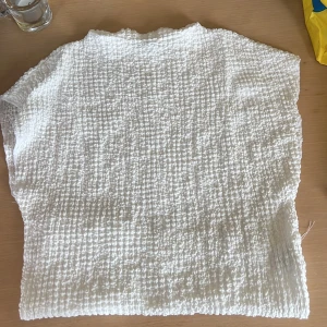 Vit strukturerad blus i bomull - Säljer en vit blus med korta ärmar och snyggt strukturerat tyg som ger en cool och unik känsla. Perfekt för dig som gillar en enkel men ändå intressant look. Passar till både jeans och kjol.