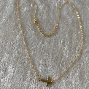 Halsband med kors i guld och Silverpläterad  - Två tunna halsband med korshänge, ett i guld och ett i silver. Båda har enkel kedja och ett stilrent kors som hänger horisontellt. Perfekt för dig som gillar minimalistiska smycken och vill ha något som sticker ut men ändå är diskret. Helt ny , 105kr/st 