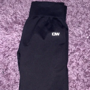 Svarta mjukisbyxor från ICANIWILL - Svarta mjukisbyxor från ICANIWILL med vit logga på ena benet. Byxorna har bred resår i midjan och är gjorda i ett mjukt och stretchigt material som passar perfekt för träning eller chill. Snygg och enkel design som funkar till det mesta.
