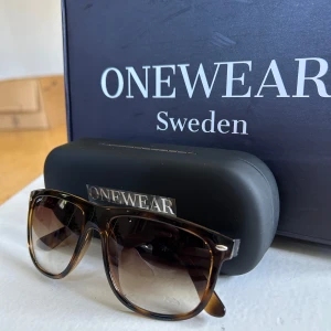 Bruna solglasögon från ONEWear Sweden - Snygga solglasögon från ONEWear Sweden med brunmelerad båge i klassisk wayfarer-stil. Glasen är tonade i brunt och bågarna har en cool sköldpaddsmönstrad look. Perfekta för att lyfta din stil under soliga dagar. Det är bara att höra av sig vid frågor och funderingar 