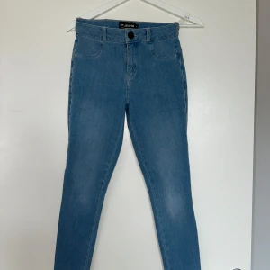 Fit Jeans 360 High Waisted - Arctic Light Blue  - Säljer ett par ljusblå jeansbyxor från Fit Jeans med klassisk femficksdesign och knappstängning. Byxorna har en smal passform och är perfekta för en stilren look. Passar till många olika outfits.