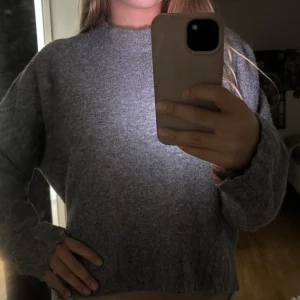Grå stickad tröja från H&M - Mysig grå stickad tröja från H&M med rund halsringning. Tröjan har en avslappnad passform och långa ärmar, perfekt för kyligare dagar. Enkel och stilren design som passar till det mesta. Xs men funkar som S också.