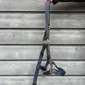 Blå grimma häst  - Säljer en marinblå grimma med silverfärgade metalldetaljer. Grimman är justerbar och har flera ringar och spännen för enkel användning. Passar perfekt till hantering av häst. I storlek cob 