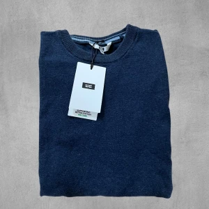 Mörkblå stickad tröja - Säljer en stickad mörkblå tröja. Tröjan är i mycket bra skick och endast använd ett fåtal gånger.