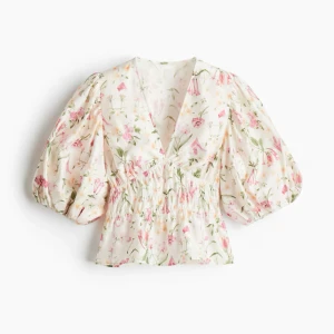 Blommig blus med puffärmar - KOMMER INTE SÄNKA MIG I PRIS! Superfin blommig blus med v-ringning och puffiga trekvartsärmar. Blusen har smock i midjan och ett romantiskt mönster i rosa, grönt och vitt. Perfekt för vår och sommar!