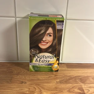 Schwarzkopf Natural & Easy hårfärg 563 - Schwarzkopf Natural & Easy hårfärg i nyansen 563, en kall brun färg från serien Nordic Naturals. Innehåller naturliga oljor och ger ett naturligt resultat med fina reflexer. Förpackningen är grön och brun med bild på en kvinna med brunt hår.