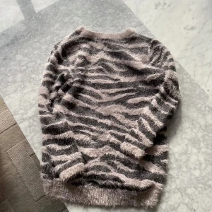 Svart/rosa fluffig zebramönstrad tröja från Lindex Kids - Säljer denna supermjuka och fluffiga tröja från Lindex Kids i svart och ljusrosa glittrigt zebramönster,för 50 kr. 💘Köpare står för frakt!