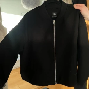 Svart bomberjacka från ZARA - Säljer en svart bomberjacka från ZARA med silverfärgad dragkedja framtill.❤️ strl L men är liten i storlek 
