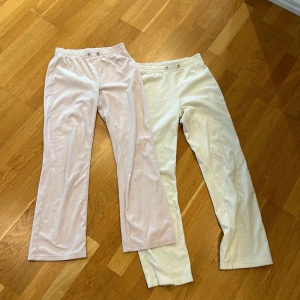Vita och ljusrosa mjukisbyxor från Gina Tricot - Två par mjukisbyxor i vitt och ljusrosa från Gina Tricot. Byxorna har normal passform, raka ben och resår i midjan med knappdetaljer framtill. Perfekta för en avslappnad stil. Om du vill köpa en så kostar det 90 och båda kostar 180