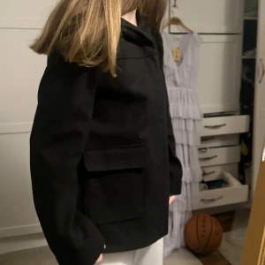 Svart jacka från Primark - Säljer en svart jacka från Primark med klassisk krage och stora fickor framtill. Jackan har lång ärm och rak passform, perfekt för en stilren look. Passar till många olika outfits.