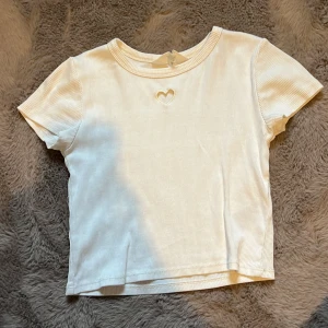 Ribbad tröja med hjärta - Säljer en jättesöt ribbad vit tröja från hm med ett hjärta. Passar till allt, en simpel men fin tröja.