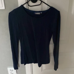 Mörkblå långärmad topp från Fransa - Aldrig andvänt!!Säljer en enkel och stilren mörkblå långärmad topp från Fransa i storlek XS. Toppen har rund halsringning och är figurnära i modellen. Perfekt att matcha med jeans eller kjol.