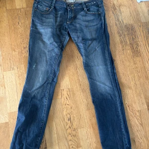 Mörkblå jeansbyxor med raka ben - Säljer ett par klassiska mörkblå jeansbyxor från G star med raka ben och fem fickor. Jeansen har orangea sömmar och detaljer vid bakfickorna. Passar perfekt till en avslappnad stil.