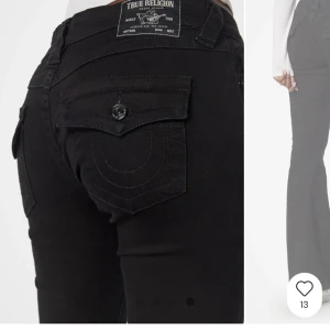 Svarta bootcut jeans från True Religion - Säljer ett par svarta jeans från True Religion med bootcut passform. Byxorna har klassiska fickor bak med knapp och dekorativa sömmar samt låg midja.