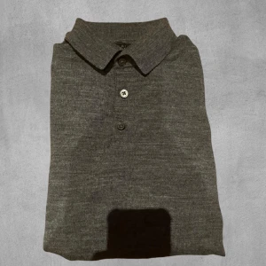 Grå långärmad piké - Säljer en grå stickad långärmad piké från Riley. Tröjan är i storlek s men sitter som xs.