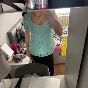 Mintgrön spetsblus - Säljer en mintgrön blus med korta ärmar och v-ringning. Blusen är helt i spets och har en feminin och fräsch look, perfekt för vår och sommar.