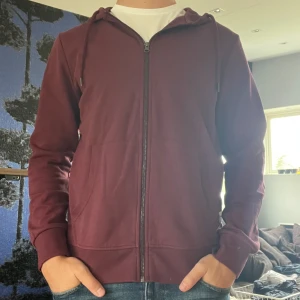 Vinröd hoodie Jack & Jones - Säljer en vinröd hoodie från Jack & Jones med dragkedja framtill och huva. Nyskick!Normal i storleken. 🤩Säljer även en svart exakt likadan där paketpris kan lösas vid köp av båda! 🍾