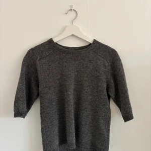 Grå stickad tröja - En enkel och stilren grå stickad tröja med rund halsringning och trekvartsärm, från Zara. Perfekt för lager-på-lager och passar till det mesta i garderoben. Snygg och tidlös design.