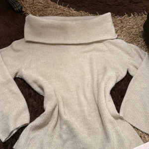 Beige stickad offshouldertröja - Säljer en beige stickad tröja med bred offshoulderkrage och långa ärmar. Den är en storlek M men har en oversized passform som en storlek L. Använd 1-2 gånger bara, köptes hos h&m för 199kr säljer för 50kr.