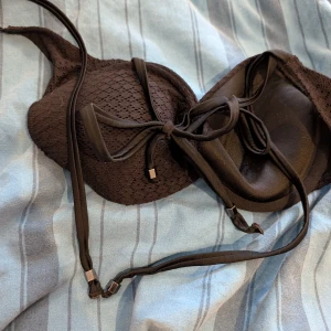 Svart bh med spets och snörning samt andra bh - Snygg svart bh med vadderade kupor och spetsdetaljer. Knytband i nacken och ryggen med små metalländar för extra stil. Ger en klassisk och stilren look. Säljer även sport bhar i 38, 36 och två extra bhr i storlek 80b. Paket med 5 hbr!