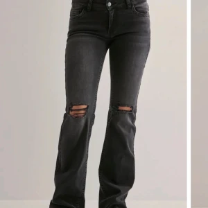 Svarta bootcut jeans med slitningar från Nelly.com.  - Snygga svarta jeans med bootcut passform och slitna hål över knäna. Jeansen har klassisk femficksdesign, hög midja och coola detaljer på bakfickorna. Perfekta för dig som gillar en edgy stil och vill sticka ut. Dom är helt oanvända, köpte fel storlek men hann ta bort prislappen. 