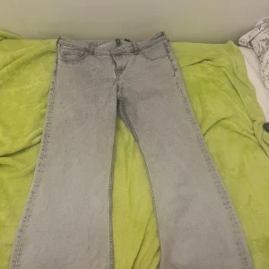 Gråa bootcut jeans - Vanliga ljusgråa low waisted bootcut jeans från HM. Använda men det enda märkbara tecknet är att delen längst ner blivit lite missfärgad men man tänker inte på det när man har på sig de då de blir smutsiga iaf. Sen gick en liten del av sömmen sönder vid fejk fickan i fram. Pris kan diskuteras