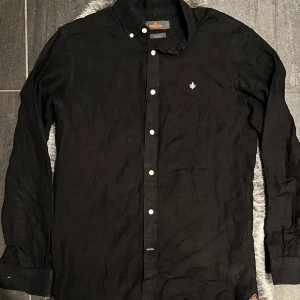 Morris Linneskjorta Svart  -   Tidlös och sval linneskjorta från Morris i elegant svart – perfekt för sommarens alla tillfällen eller som stilrent lager under höstjackan.  Storlek S, men sitter mer som en M Mycket fint skick, sparsamt använd