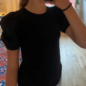 Svart topp med puffärmar från H&M - Svart topp från H&M i storlek XS med puffärmar.