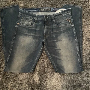 Replay anbass jeans - Säljer nu ett par tvärfeta replay anbass jeans med en mörkblå färg och snygg tvätt. Jeansen har en slim passform och W32, passar dig som är runt 182 cm. Tveka inte att höra av dig vid ytterligare frågor eller bilder!