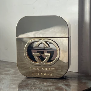 Gucci Guilty Intense parfym - Gucci Guilty Intense är en lyxig parfym i en stilren, guldig metallflaska med det ikoniska GG-emblemet. Doften har toppnoter av rosa peppar och mandarin, hjärtnoter av syren, viol och heliotrop samt basnoter av amber och patchouli. Flaskan har en modern, fyrkantig form. 50ml flaska, ca 10ml använt