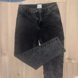 Svarta jeans från Grunt, storlek 25 som 27! - Snygga svarta jeans från Grunt i tvättad look. Modellen har klassisk femficksdesign, dragkedja och knapp framtill. Jeansen är raka i benen och tillverkade i ekologisk bomull för en skön känsla och stilren vibe.