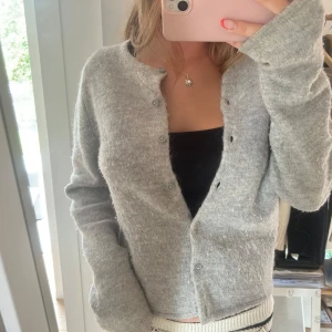 Stickad kofta Gina  - Säljer denna grå stickade kofta från Gina!