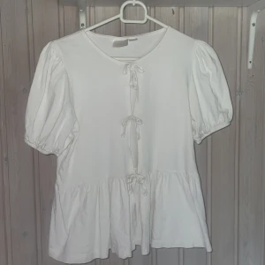 Vit blus med rosetter💓 - Supersöt vit blus från Gina Tricot med puffiga ärmar💞den är väldigt fin på och perfekt för dig som gillar att ha trendigt😍säljer för att den inte kommer till användning men har använt få gånger⭐️