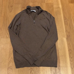Brun half zip tröja från Selected Homme - Snygg brun långärmad tröja från Selected Homme med half zip-dragkedja i halsen. Tröjan har ribbade muddar och är tillverkad i mjukt bomullsmaterial. Perfekt för lager-på-lager och chill stil. Lite skrynklig förlåt för det. Nypris 600