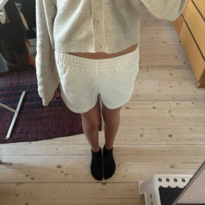 Vita shorts från Gina Tricot - Snygga vita shorts från Gina Tricot i mjuk bomull. De har elastisk midja och en avslappnad passform med fickor på sidorna. Perfekta för varma dagar och chill outfits. Klassisk look som är lätt att matcha med allt. Är sydda high waist så åker upp lätt!