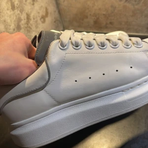 Alexander McQueen skor  - Säljer nu dessa riktigt snygga och unika vita skor från Alexander McQueen som är nästan nya i skick! Nypris är ca 6500kr! Väldigt sällsynt och eftertraktad modell med reflexdetaljer🤩 Skriv vid funderingar! Storlek 40 men passar möjligtvis 39 😁
