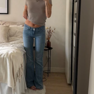lågmidjade Bootcut jeans från Nelly - Snygga bootcut jeans från Nelly i ljusblå denim. Modellen är lågmidjad med två knappar framtill, stora framfickor och bakfickor med lock och knapp. Jeansen har en klassisk bootcut passform och är tillverkade i bomull med lite stretch för extra komfort. Använda fåtal gånger. Säljer då de är inte min stil 🌸
