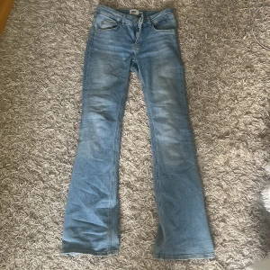 Bootcut jeans i ljusblå denim från 157 - Snygga ljusblå low bootcut jeans från 157 med klassisk femficksdesign och bälteshällor. Jeansen har en lätt tvättad look och är tillverkade i mjuk denim som sitter skönt. Perfekta för dig som gillar en avslappnad men trendig stil. Storlek xs men skulle säga att de passar S mer